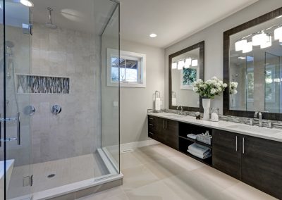 bathroom with glass shower and double sinks