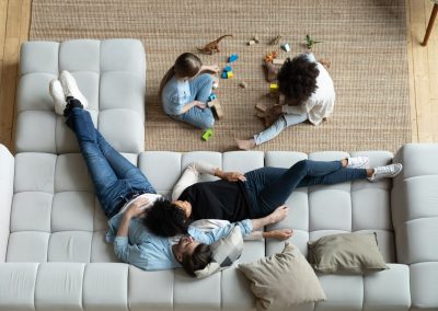 aerial view of couple on couch with kids playing on floor